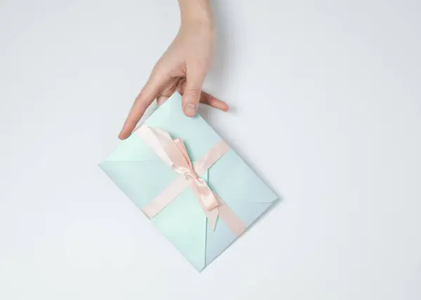 Mavi hediye zarfını tutarken