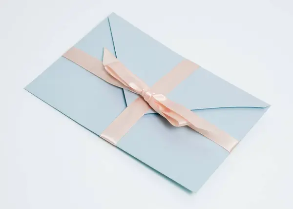 Beyaz arkaplanda mavi hediye zarfı veya sertifika