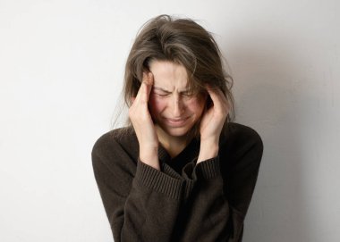 Şakaklarını tutan kadın, baş ağrısı