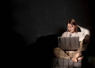 Serbest çalışan biri evde dizüstü bilgisayarla çalışıyor.