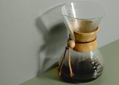 Gri yeşil arka planda sıcak demlenmiş Chemex kahve makinesi..