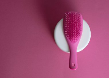 Güzellik gösterisi için kozmetik şişesi ve pembe tarak.