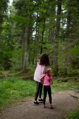 Anne ve kızı el ele yürüyorlar.