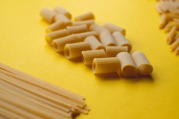 Cannelloni ve şehriyeler canlı sarı arka planda dizilmiş.
