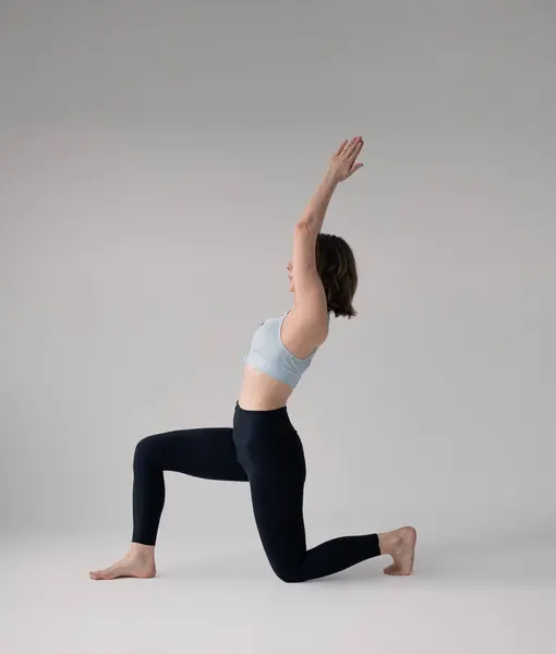 Sporcu kadın antrenmandan önce geriniyor.