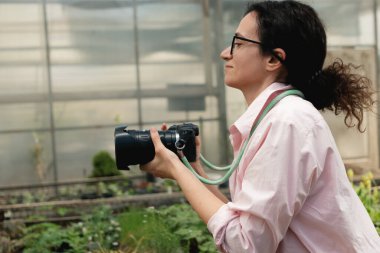 Bitkileri yakalamak için kamera kullanan kadın