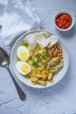 Kahvaltıda Endonezya yemeği 'Bubur Ayam, doğranmış tavuk, haşlanmış yumurta, yeşil soğan ve krupuk karides krakeri ile servis edilen pirinç lapasından yapılır.