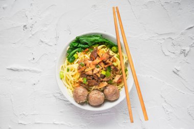 Endonezya sokak yemeği mie ayam, beyaz arka planda köfte ve sambal biber ezmesi ile servis edilen tavuk eriştesidir.