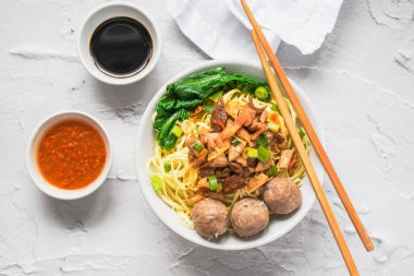 Endonezya sokak yemeği mie ayam, beyaz arka planda köfte ve sambal biber ezmesi ile servis edilen tavuk eriştesidir.