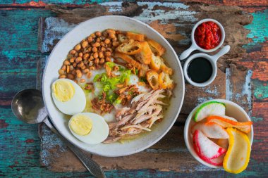 Bubur ayam, Endonezya pirinç lapası dilimlenmiş tavuk haşlanmış yumurta, karides krakeri ve acılı sambal sosuyla servis ediliyor.