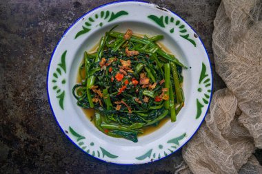 Tumis kangkung is Stir Fried Water Spinach cooked with spices  clipart