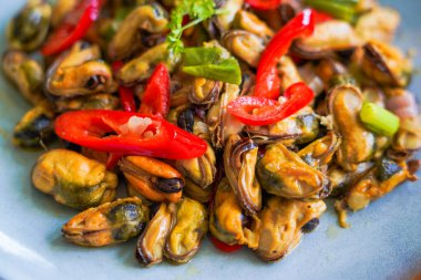 Tumis Kerang Kupas, bir dilim kırmızı biber, soğan, sarımsak ve diğer baharatlarla karıştırılmış midye..