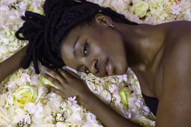 Studio portrait of young woman lying on flowers