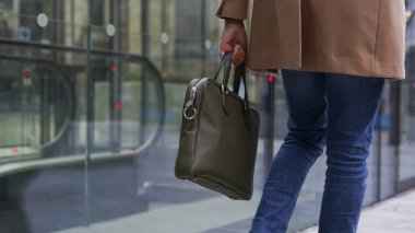 Mid section of business man carrying bag