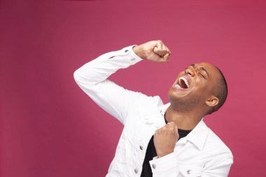 Smiling man punching air and celebrating