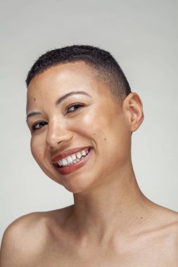 Gülümseyen üstsüz kadının stüdyo portresi.