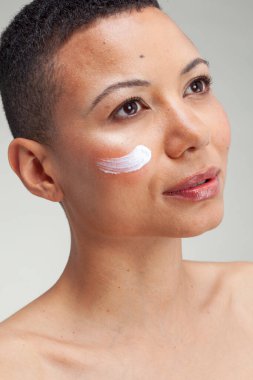 Studio portrait of woman with facial cream on cheek