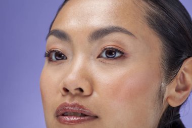 Close-up of woman against purple background