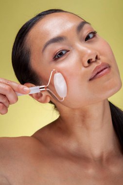 Studio shot of woman using quartz roller
