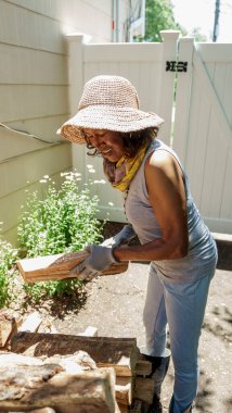Kıdemli kadın yakacak odun topluyor.