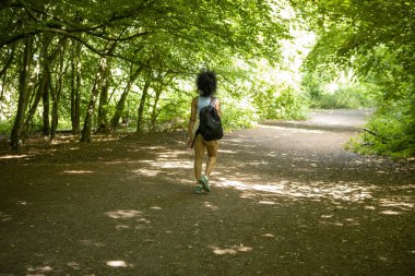 Ormanda yürüyüş yapan genç bir kadın, dikiz aynasından