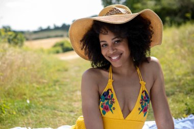 Yaz şapkası takan genç bir kadının portresi.