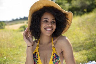 Yaz şapkası takan genç bir kadının portresi.