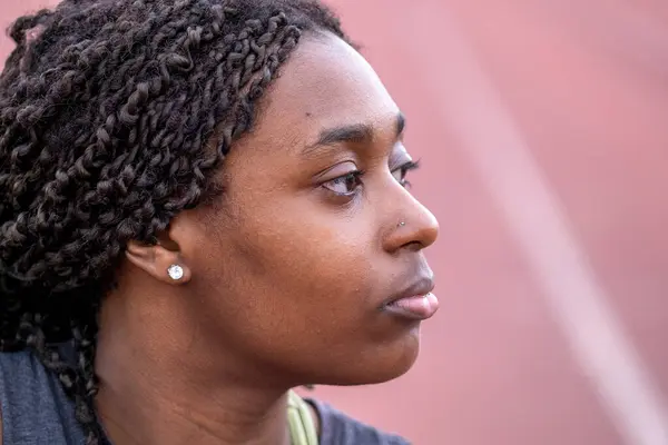 Koşu pistinde oturan atletik kadının yakın çekimi