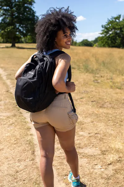 Kırsalda yürüyüş yapan genç bir kadın.