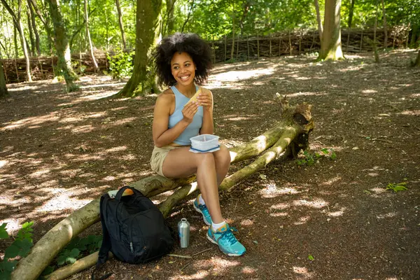 Ormanda atıştırmalık yiyen bir kadın sırt çantası.