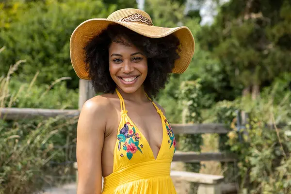 Yaz şapkası takan genç bir kadının portresi.