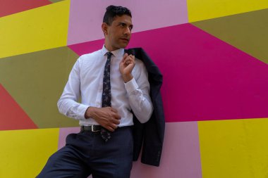 Renkli duvara karşı duran iş adamı