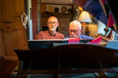 Evde piyano çalan son sınıf erkek çifti.