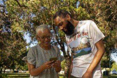 Parkta akıllı telefon kullanan çift