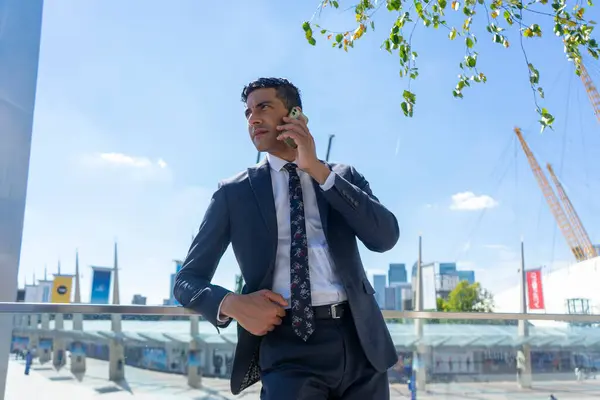 İş adamı dışarıda telefonla konuşuyor.