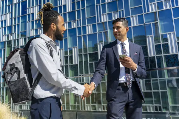 İki işadamı iş bölgesinde el sıkışıyor.