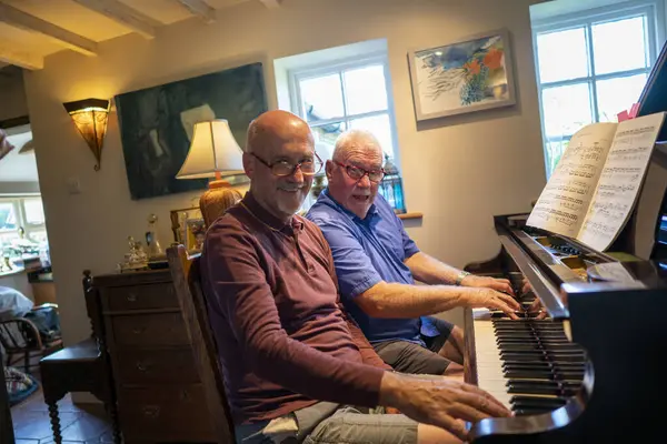 Evde piyano çalan son sınıf erkek çifti.