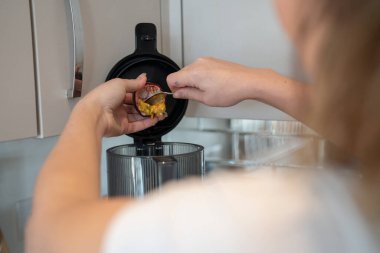 Woman using blender in kitchen