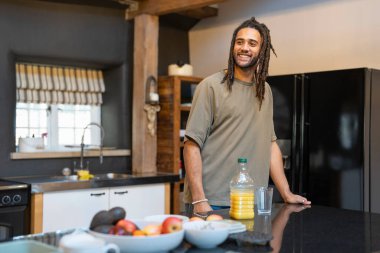 Man with dreads standing in kitchen