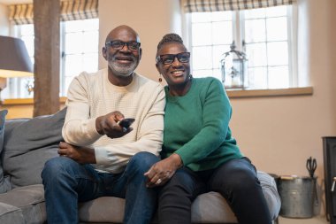 TV izlerken gülümseyen kıdemli Çift