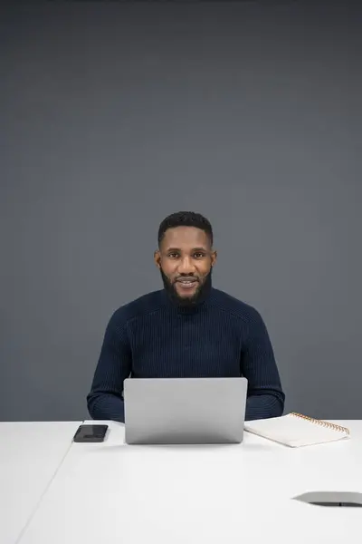 Ofiste dizüstü bilgisayarda çalışan genç işadamının portresi