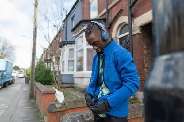 Açık hava antrenmanından önce kulaklık takan bir sporcu.