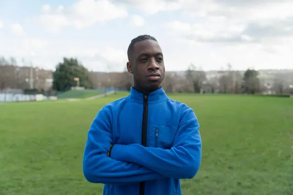 Parktaki çimlerin üzerinde duran bir sporcunun portresi