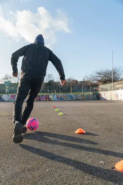 Bir adamın dışarıda futbol antrenmanı yaptığını hayal edin.