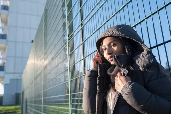 Çitlere dayanmış kapüşonlu kadın portresi