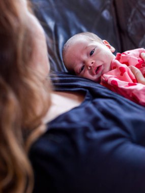 Anne küçük kızıyla kanepede yatıyor.