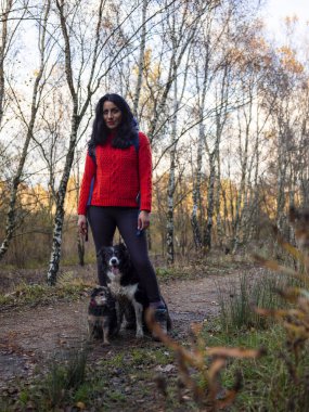 Ormanda köpeklerle gezen bir kadın.