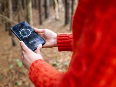 Akıllı telefonda pusula kullanan kadın yürüyüşçü