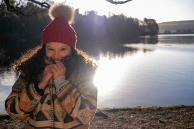 Gölde gülümseyen genç bir kadının portresi