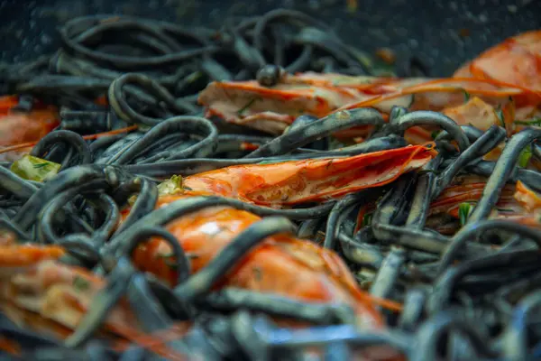 Tereyağlı taze deniz mahsullü siyah spagetti, beyaz şarap ve sarımsak sosu. Taze kaplan karidesli lüks bir tabak..